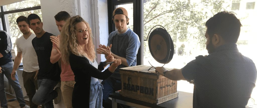 SoapBox Employee hitting a gong